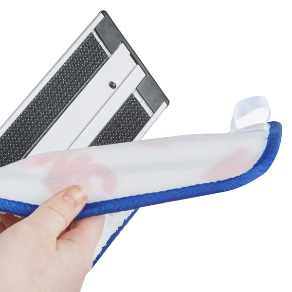 A hand holding a white and blue 3M mop pad.