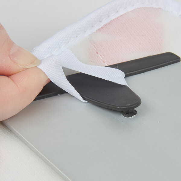 A person using scissors to cut a green fabric pad.