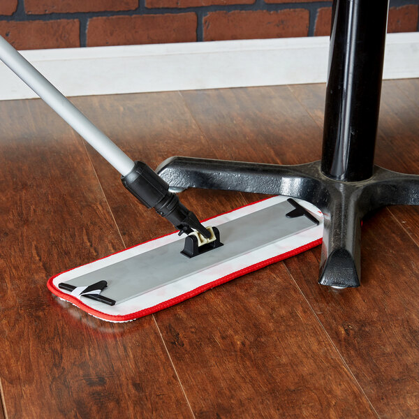 A 3M red wet mop pad on a wooden floor.