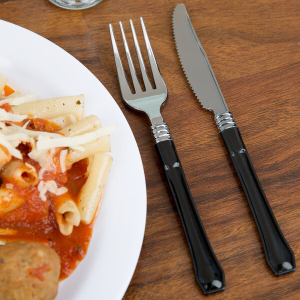 A plate of pasta with a knife and fork on a table.