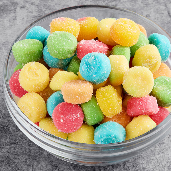 A bowl filled with Albanese Sour Gummi Poppers on a table.