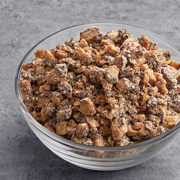 A bowl of Chopped Brown & Haley Almond Roca Topping on a table.
