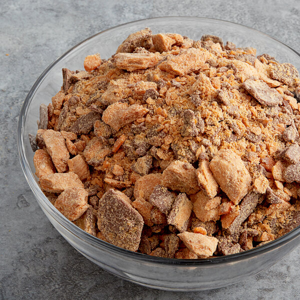 A bowl of brown and white food topped with chopped Butterfinger candy.