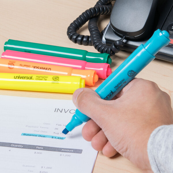 A hand holding a Universal desk style highlighter over a paper.
