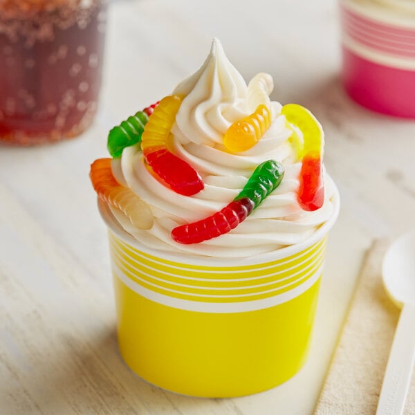 A cupcake with whipped cream and Albanese mini gummi worms on top.