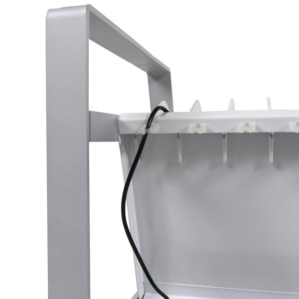 A white metal shelf with a cord attached to it.