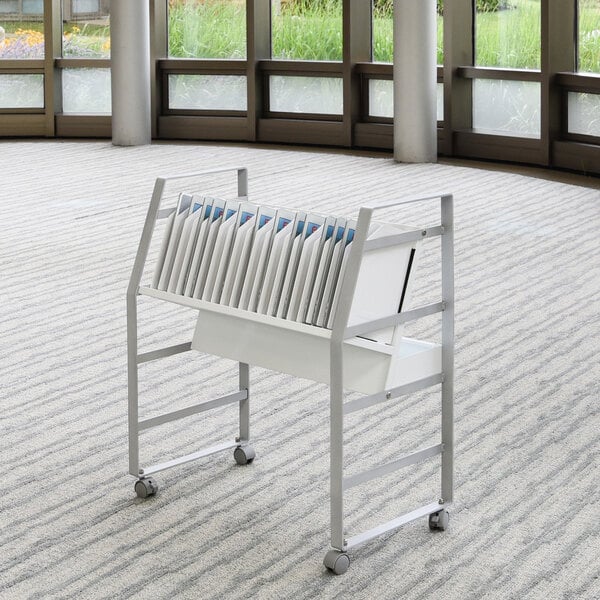 A white metal Luxor charging cart with tablets on it.