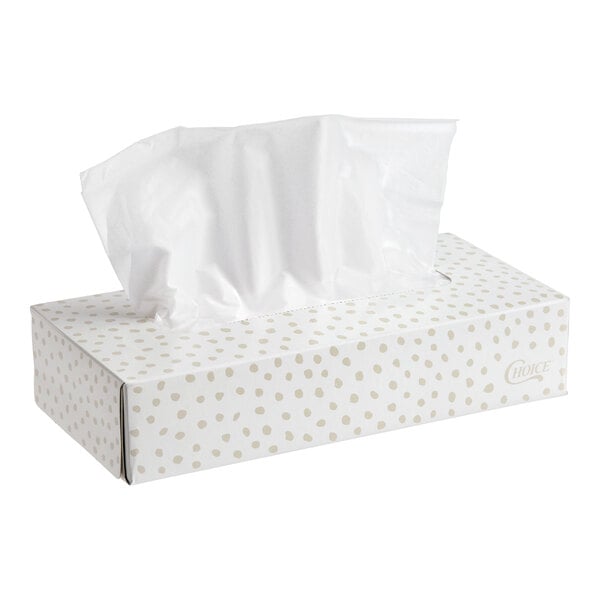 A rectangular box of facial tissues with a white and beige polka dot design and one tissue partially pulled out.