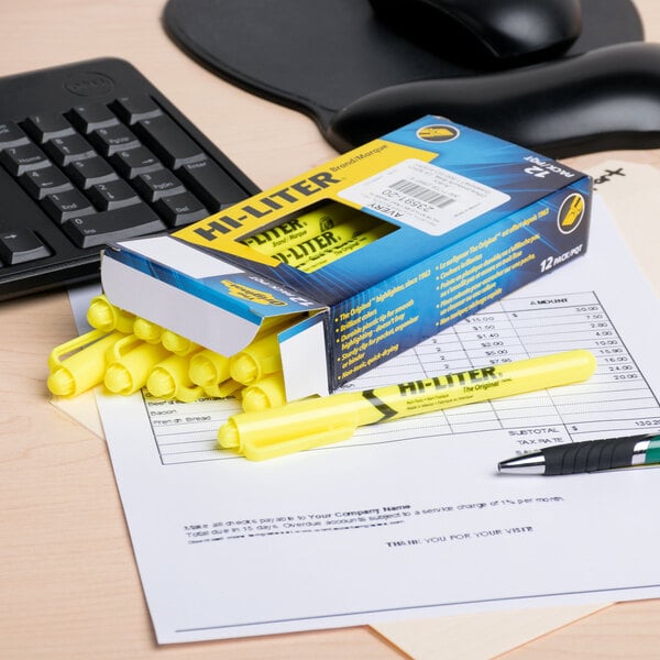 A box of Avery Hi-Liter Fluorescent Yellow Highlighters on a desk with one yellow highlighter on top.