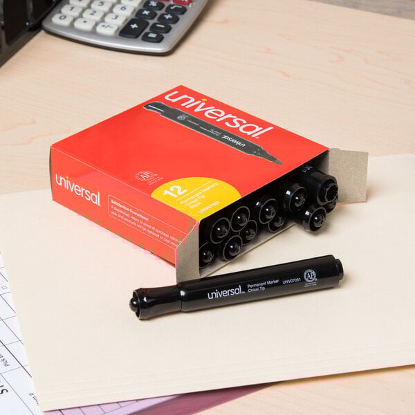 A box of Universal black chisel tip permanent markers on a desk.