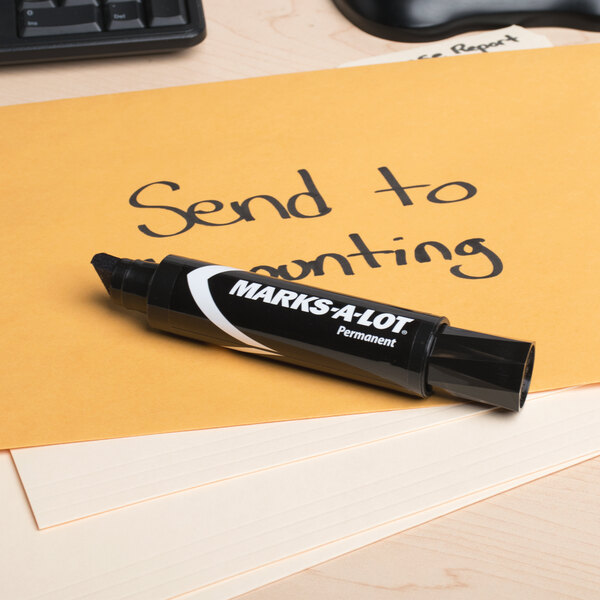 A black Avery Marks-A-Lot marker writing on a yellow envelope.