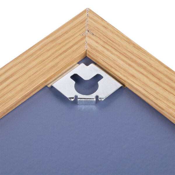 A natural cork board with an oak frame and metal clips.