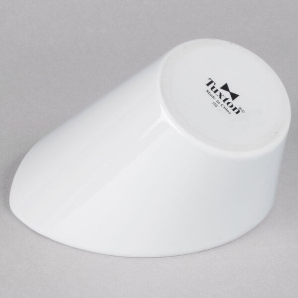 A Tuxton bright white china bowl on a white surface.