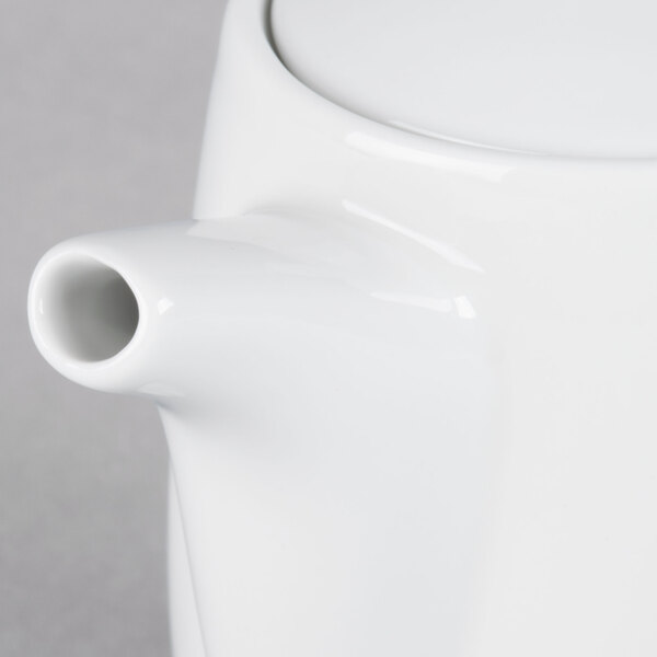 A close-up of a white TuxTrendz teapot with a lid.