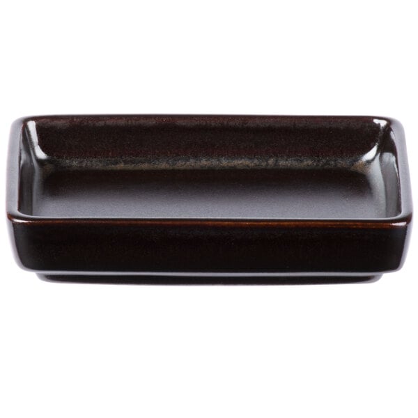 A rectangular brown Tuxton China sauce dish with a black rim.