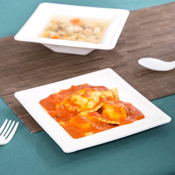 A bowl of ravioli with sauce in an EcoChoice sugarcane bowl on a table.