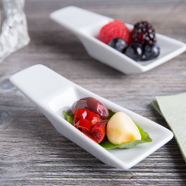 A Tuxton TuxTrendz bright white rectangular tasting spoon filled with fruit.