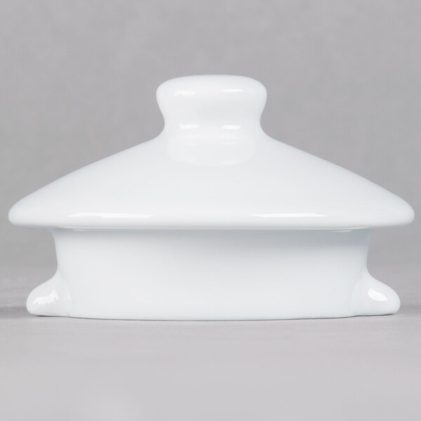 A TuxTrendz white ceramic teapot lid with a small handle.