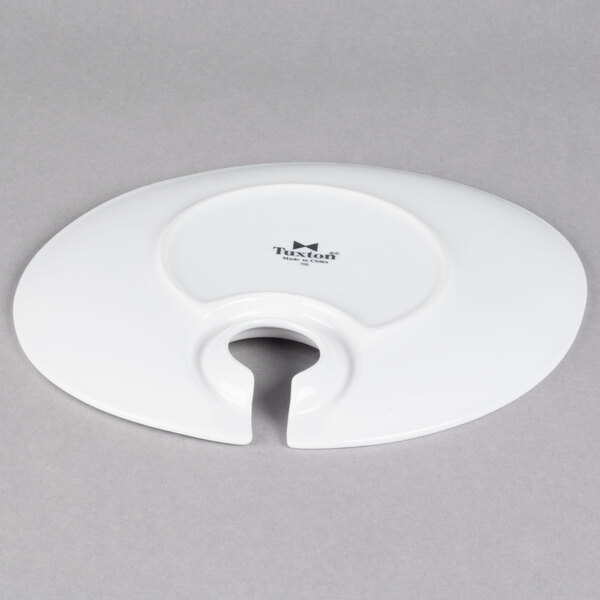 A white Tuxton china appetizer plate with a hole in the middle.