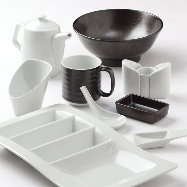 A white plate with a Tuxton bright white oval tasting spoon on it.