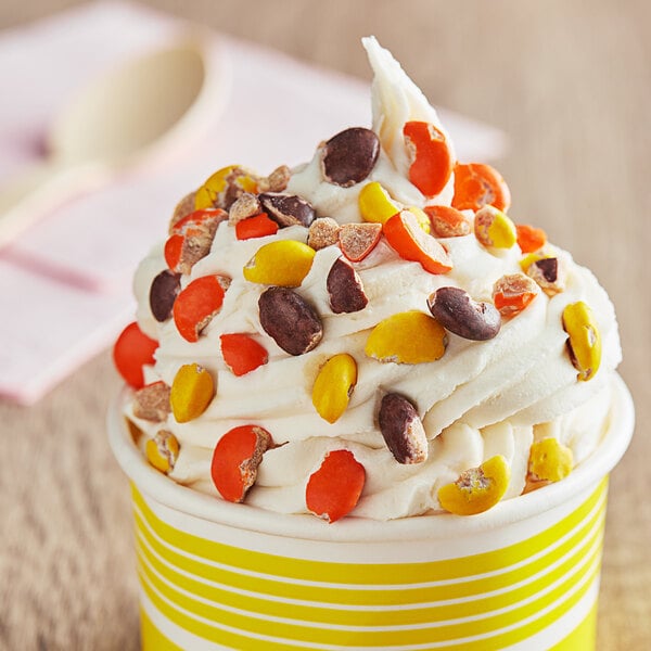 A cup of ice cream with Chopped REESE'S PIECES® candy on top.