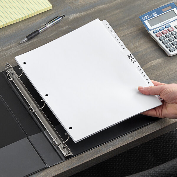 A person holding a white paper in Avery Legal Exhibit Dividers in a binder.