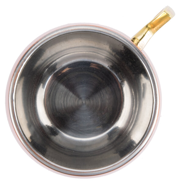 An American Metalcraft mirrored copper Moscow Mule mug with a gold handle.