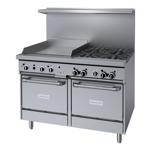 A stainless steel Garland gas range with 4 burners on a counter in a professional kitchen.