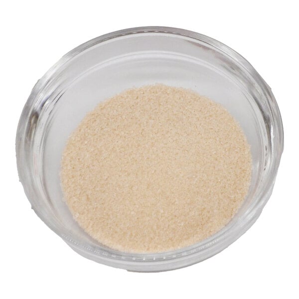 A bowl of brown sugar on a white background.