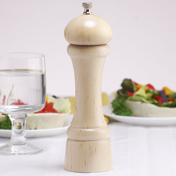 A close-up of a wooden Chef Specialties Windsor pepper mill on a table.