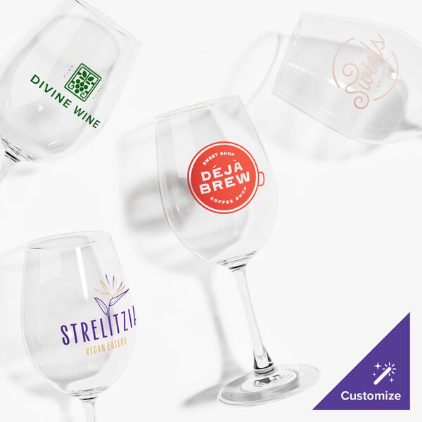 A group of clear Acopa Select wine glasses with orange custom writing.