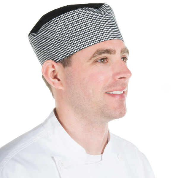 A man wearing a black and white houndstooth Chef Revival baker's skull cap.