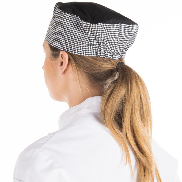 A woman wearing a Chef Revival black and white checkered baker's hat.