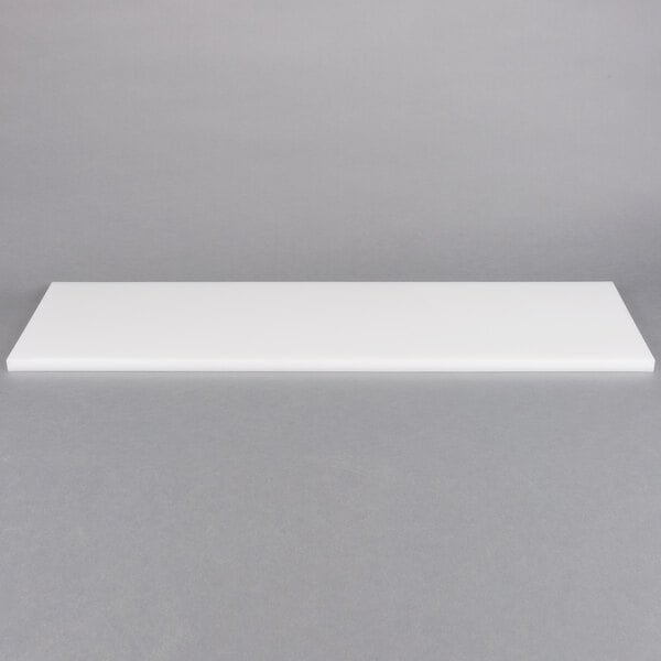 A white rectangular object on a gray surface.