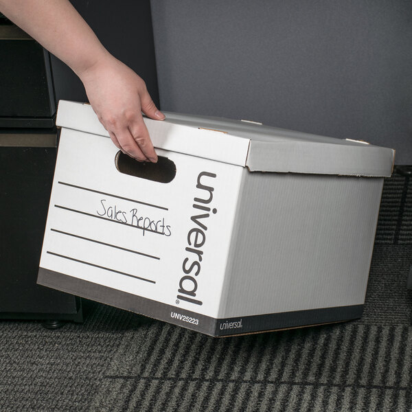 A person's hand holding a white Universal storage box.