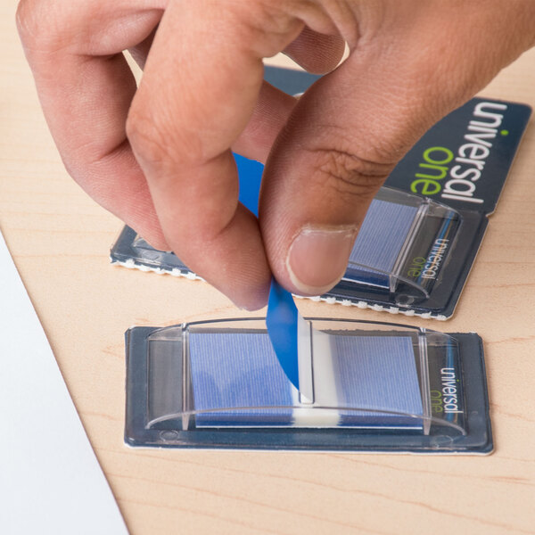 A person's hand holding a Universal blue page flag dispenser.