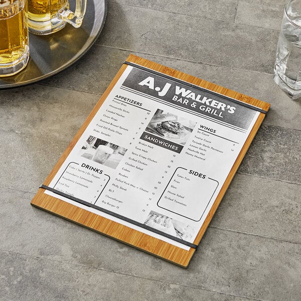 A Choice natural wood menu holder with straps on a table with a glass of beer on it.