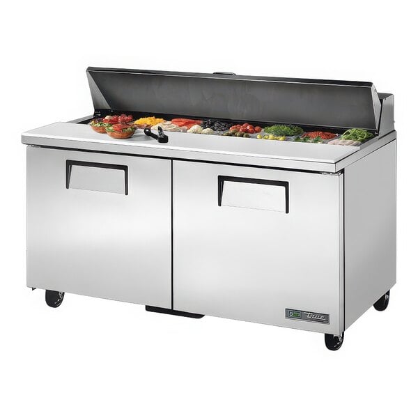 A True stainless steel refrigerated sandwich prep table with food on top.