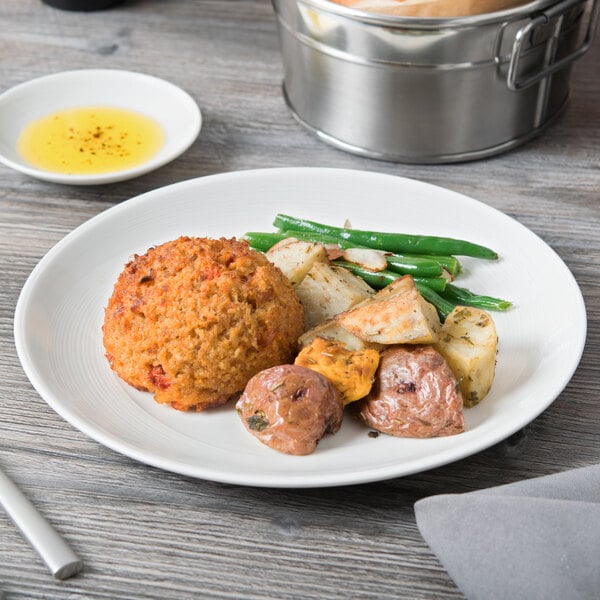 A Reserve by Libbey white porcelain coupe plate with food on it on a table.