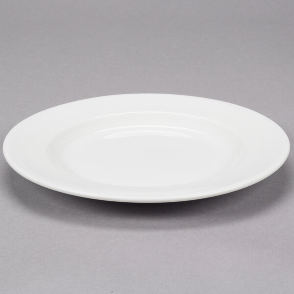 A white Reserve by Libbey Royal Rideau porcelain plate with a wide rim.