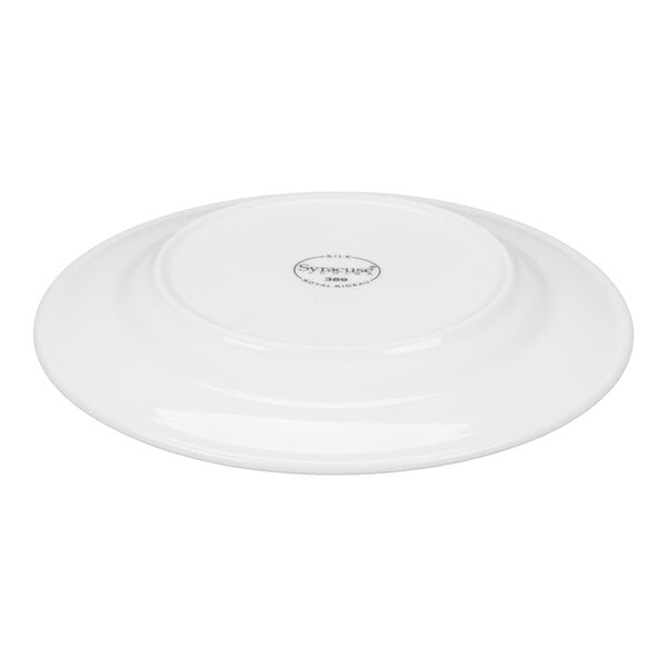 A white porcelain plate shown upside down with a visible maker's mark at the center.
