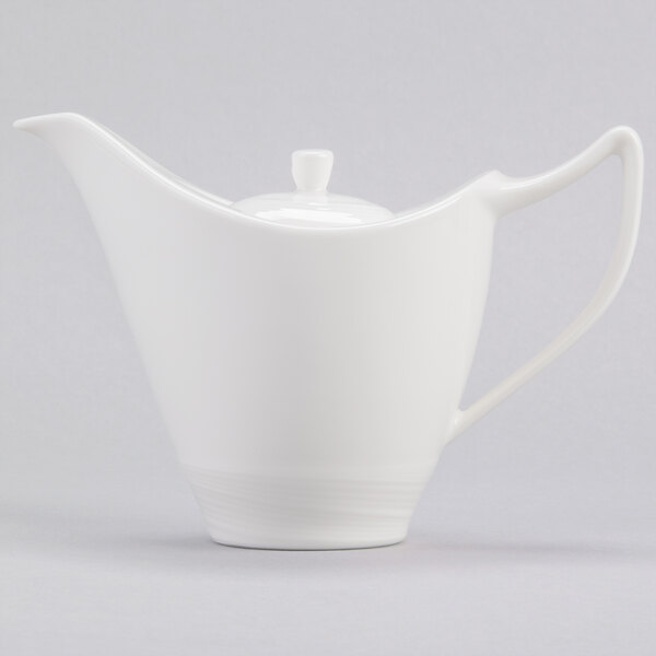 A close up of a white Royal Rideau porcelain teapot with lid and handle.