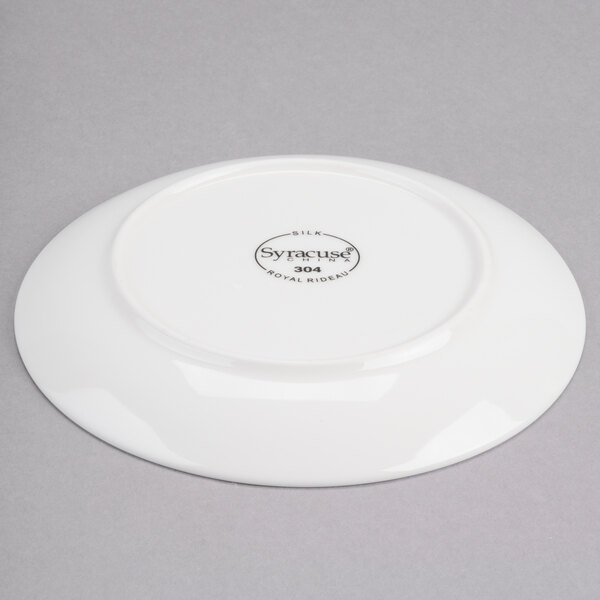 A white porcelain coupe plate with a circular design on it.