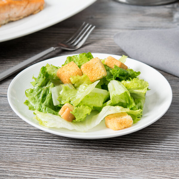 A Reserve by Libbey white porcelain coupe plate with a salad on it.