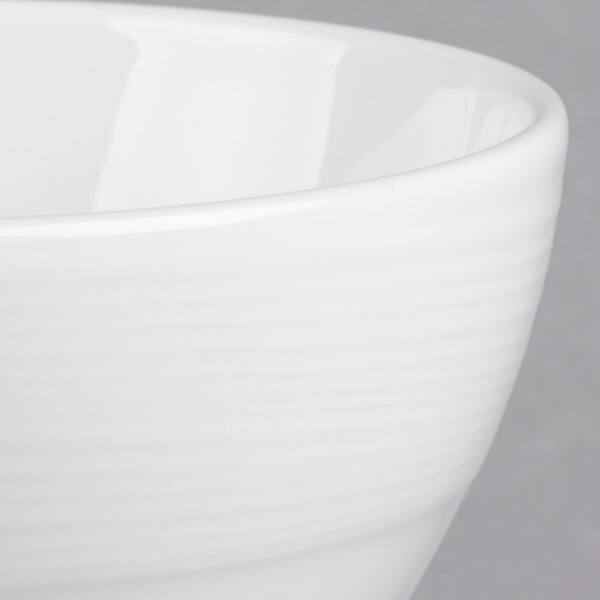 A close up of a white Royal Rideau Silk porcelain bouillon bowl with a rim.