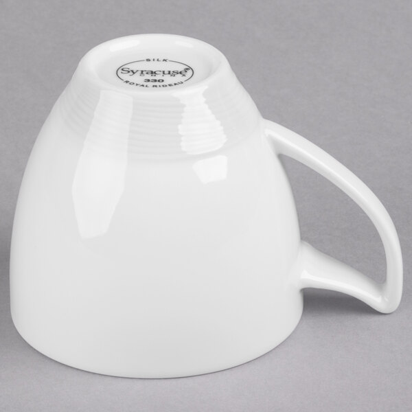 A close-up of a white Reserve by Libbey Royal Rideau porcelain coffee mug with a handle.