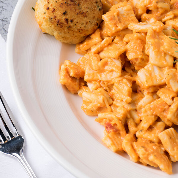A Reserve by Libbey Royal Rideau white porcelain pasta bowl filled with pasta and a fork.