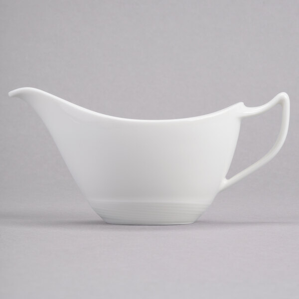 A white porcelain sauce boat with a handle.