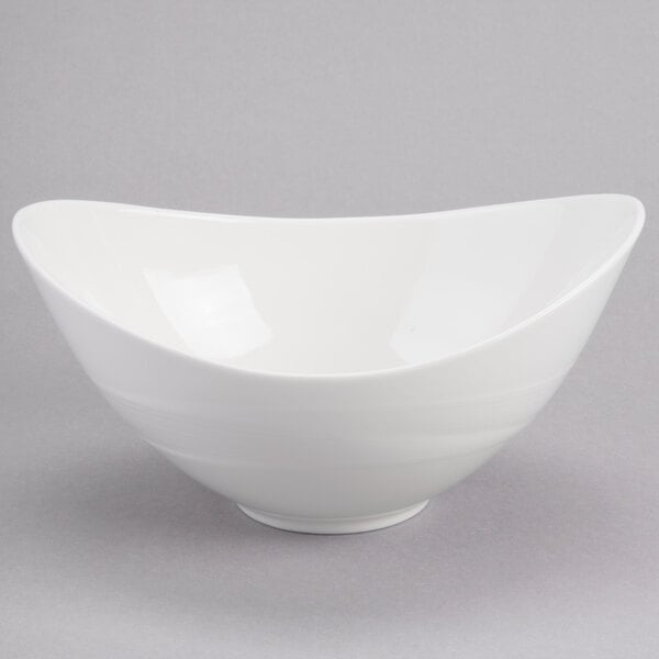 A white bowl with a curved edge on a gray surface.