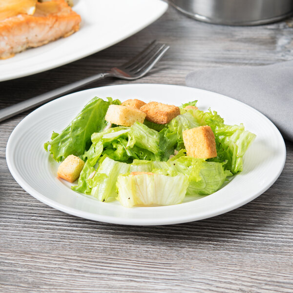 A Reserve by Libbey Royal Rideau white porcelain plate with a salad and meat.